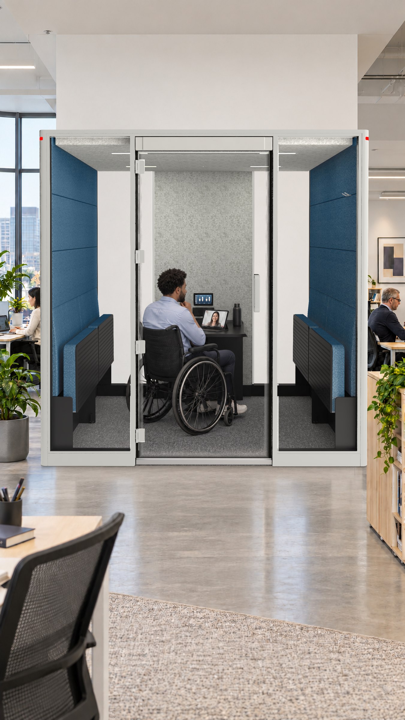 A Calma For All pod, a man in a wheelchair on a video call at the desk inside